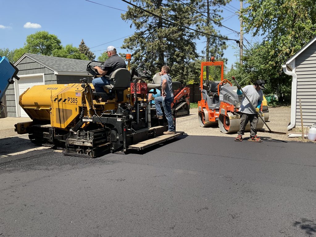 men paving a new driveway with asphalt