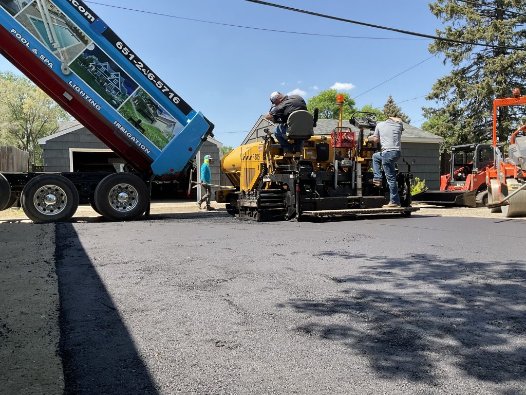 men paving a new driveway with asphalt