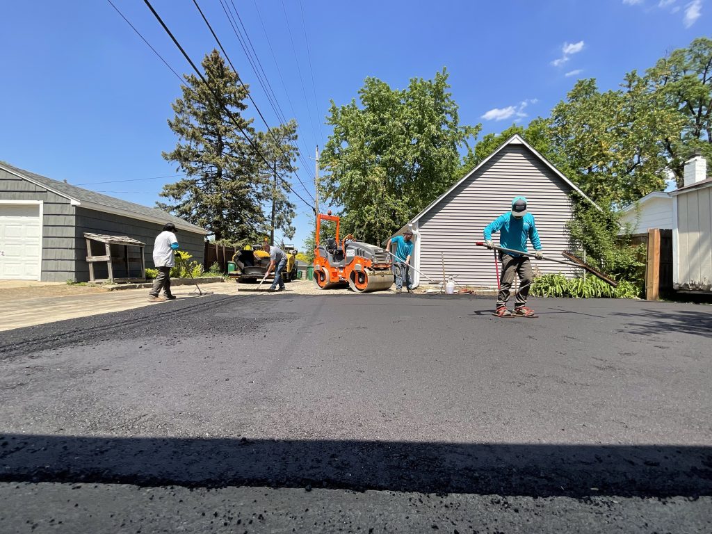 men paving a new driveway with asphalt